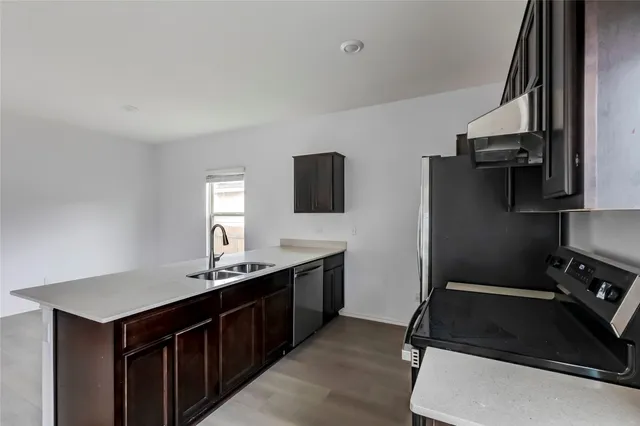 a kitchen with stainless steel appliances granite countertop a sink stove and refrigerator