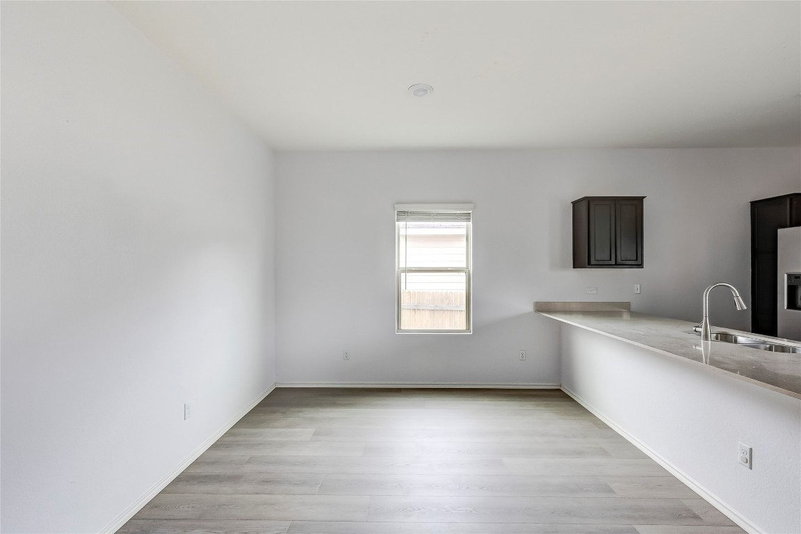 772 Circle Way Jarrell, TX 76537 - Photo 14 of 35 Kitchen featuring light wood-style flooring, stainless steel fridge, and dark brown cabinetry