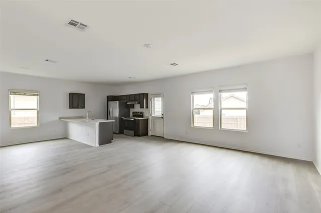 an empty room with windows and fireplace