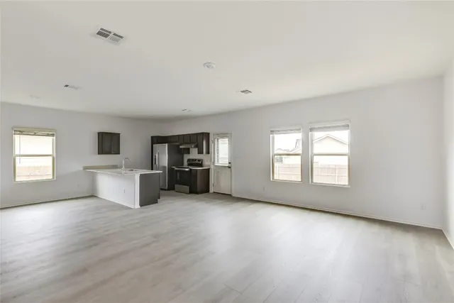 an empty room with windows and fireplace