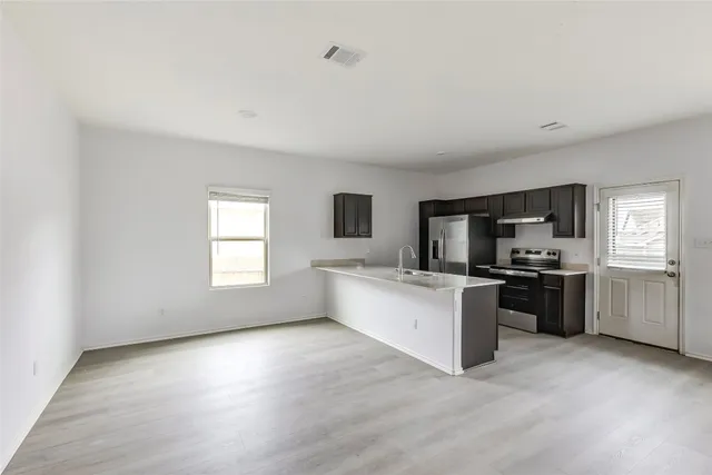 a view of an empty room with wooden floor