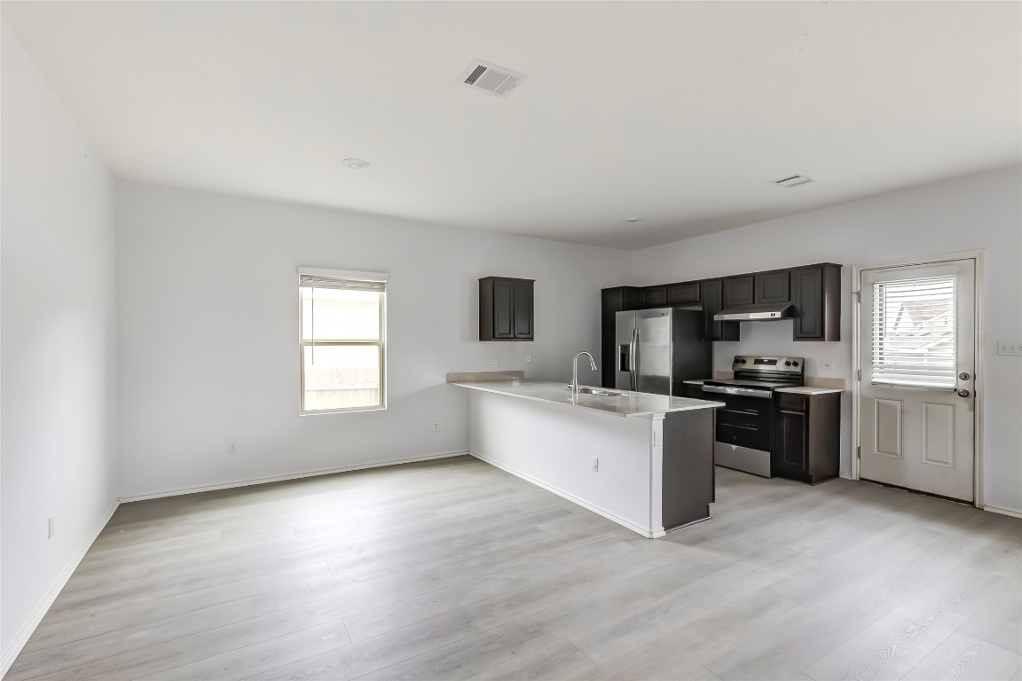 772 Circle Way Jarrell, TX 76537 - Photo 9 of 35 Kitchen featuring appliances with stainless steel finishes, a peninsula, light wood-style floors, and healthy amount of natural light
