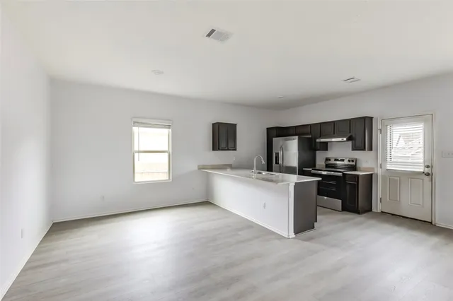a view of an empty room with wooden floor
