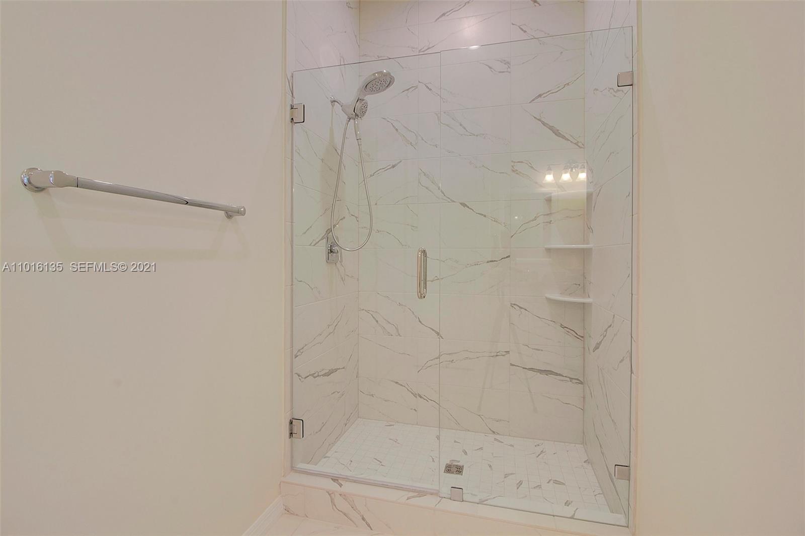 9127 Passiflora Way, Unit 201 Boca Raton, FL 33428 - Photo 11 of 31 Shower with frameless glass doors, rain-like shower head, and granite shelves.