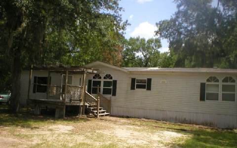 4183 West H Waters Road Callahan, FL 32011 - Photo 1 of 1 a backyard of a house with yard and garage