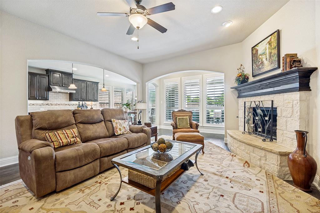 3036 Avondale The Colony, TX 75056 - Photo 11 of 40 An open and inviting living space that flows seamlessly into the kitchen, filled with natural light and centered around a cozy fireplace.