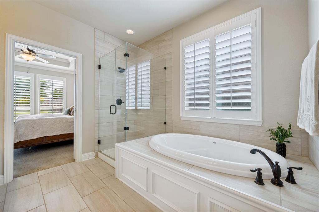 3036 Avondale The Colony, TX 75056 - Photo 21 of 40 A bright and relaxing ensuite bath with a soaking tub, frameless glass walk-in shower, and beautiful natural light throughout.