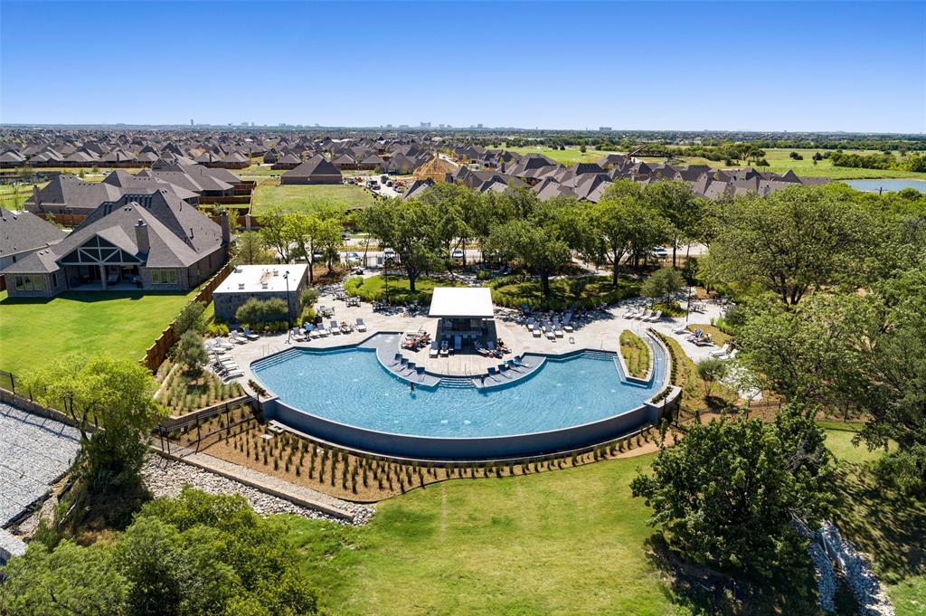 3036 Avondale The Colony, TX 75056 - Photo 36 of 40 This stunning lakeside pool offers a true resort-style experience, perfectly positioned on the shoreline of Lake Lewisville. Lounge areas, shaded seating, and a central pavilion provide the ideal setting for relaxing or gathering with friends, all while overlooking lush green space and serene water views. As the day winds down, the sky transforms into a canvas of color, making this the perfect place to unwind and take in those unmatched Texas sunsets.