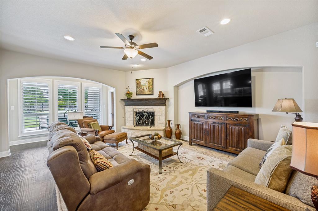 3036 Avondale The Colony, TX 75056 - Photo 10 of 40 A comfortable and inviting living space featuring a beautiful fireplace, abundant natural light, and plenty of room to unwind or entertain.