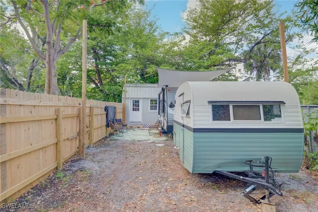 a view of a house with a backyard and wooden fence