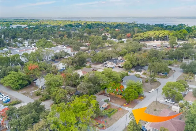 an aerial view of residential houses with outdoor space and trees