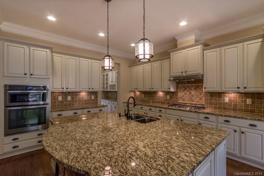 1600 Buckland Court Indian Land, SC 29707 - Photo 11 of 24 a kitchen with kitchen island granite countertop a sink cabinets and stainless steel appliances