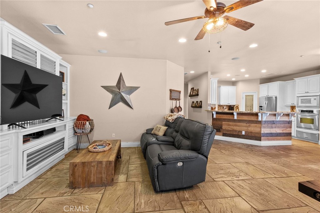 7381 Cygnet Road Phelan, CA 92371 - Photo 16 of 64 a living room with furniture a flat screen tv and kitchen view