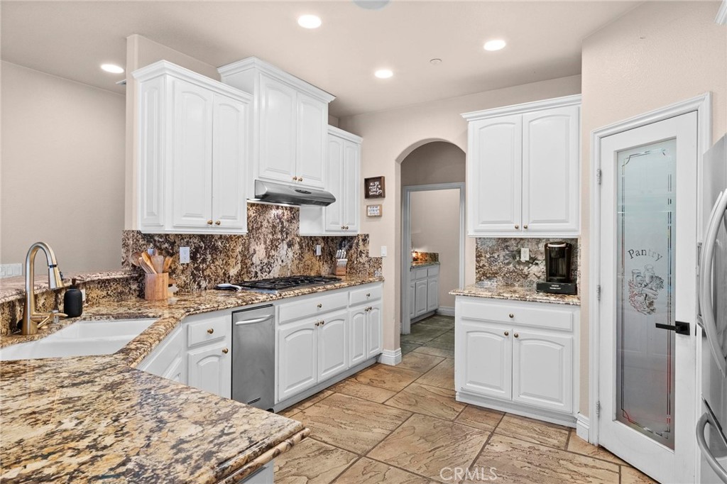 7381 Cygnet Road Phelan, CA 92371 - Photo 19 of 64 a kitchen with stainless steel appliances granite countertop a sink stove and refrigerator
