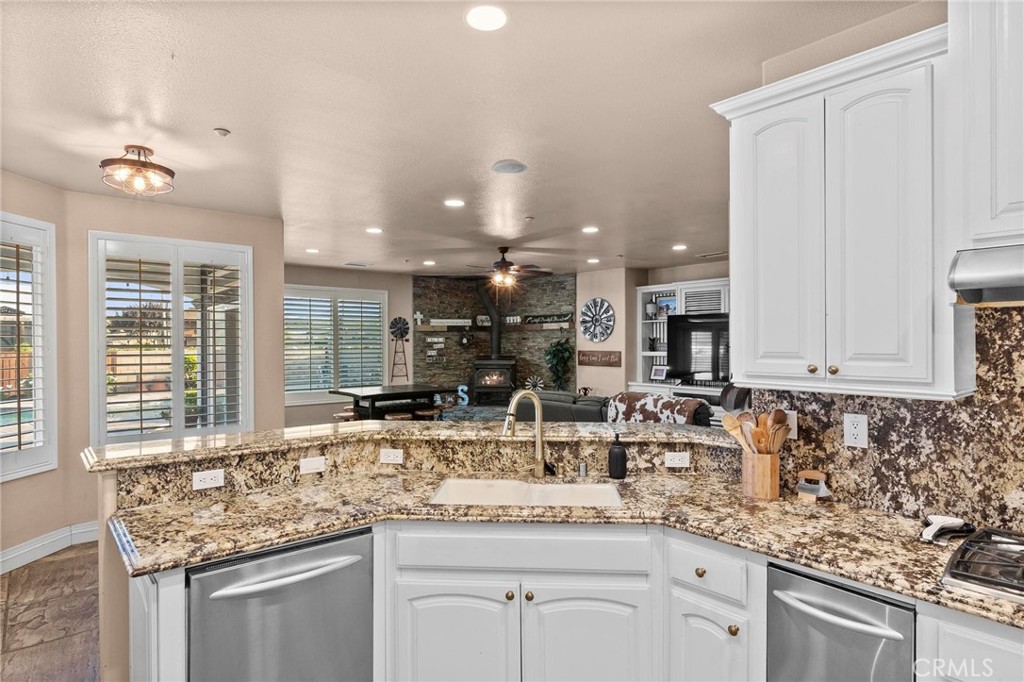 7381 Cygnet Road Phelan, CA 92371 - Photo 21 of 64 a kitchen with granite countertop a sink and white cabinets