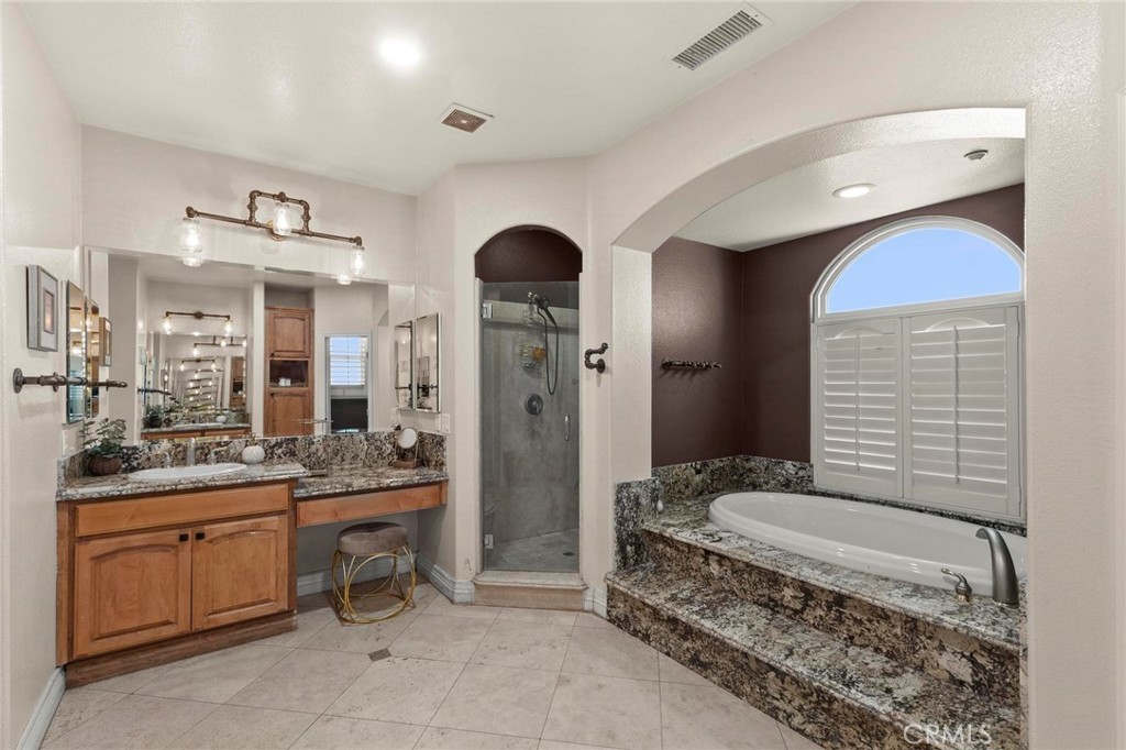 7381 Cygnet Road Phelan, CA 92371 - Photo 30 of 64 a spacious bathroom with a granite countertop sink a mirror and a shower