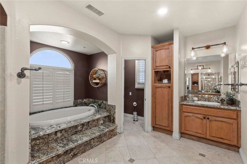 7381 Cygnet Road Phelan, CA 92371 - Photo 31 of 64 a spacious bathroom with a granite countertop sink a mirror and a shower