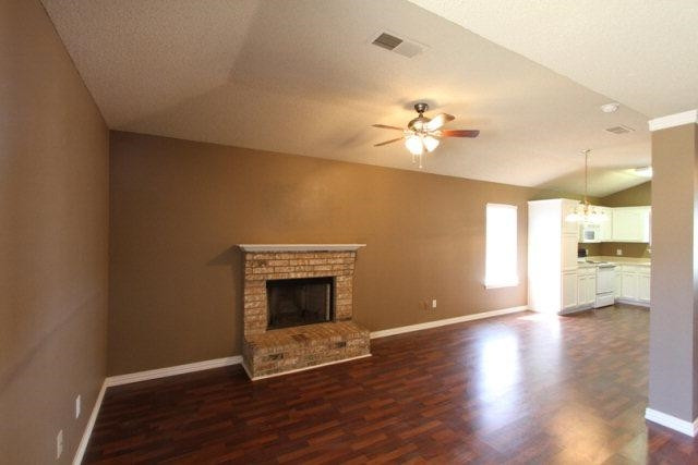 2723 110th Street Lubbock, TX 79423 - Photo 3 of 10 a view of an empty room with a fireplace and a chandelier fan
