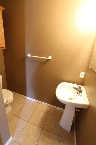 2723 110th Street Lubbock, TX 79423 - Photo 10 of 10 a bathroom with a sink a toilet and a mirror