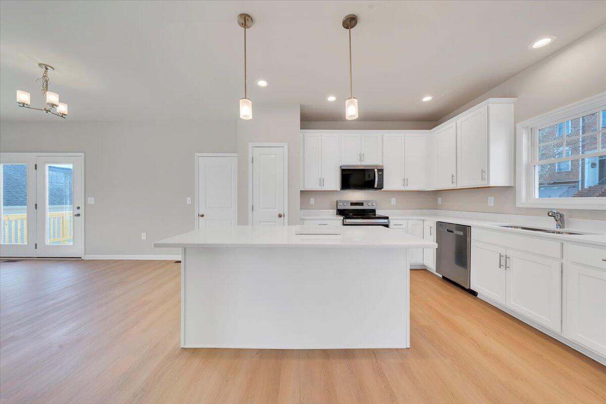 3711 Crescent Ridge Drive Southwest Roanoke, VA 24015 - Photo 5 of 23 a kitchen with stainless steel appliances granite countertop a sink a stove a refrigerator and white cabinets with wooden floor