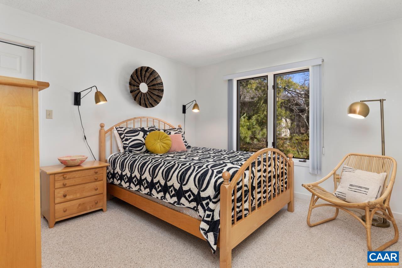 2016 Stone Rdg Wds Roseland, VA 22967 - Photo 17 of 32 a bed sitting in a bedroom next to a window with a chandelier