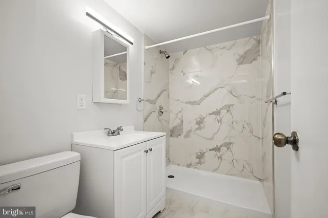 a bathroom with a sink a toilet and shower