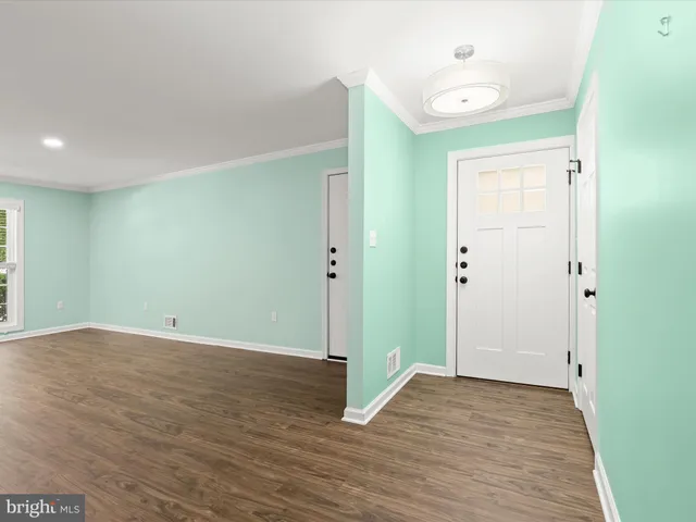 a view of an empty room with wooden floor