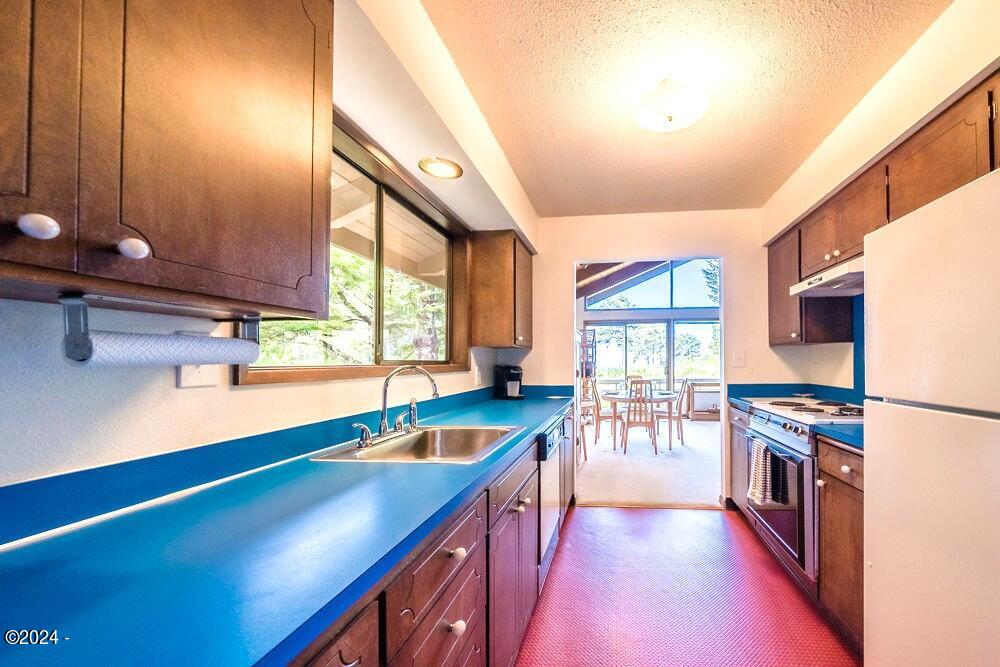 114 Ridge Crest Road Gleneden Beach, OR 97388 - Photo 14 of 40 a kitchen with lots of counter top space and wooden floor
