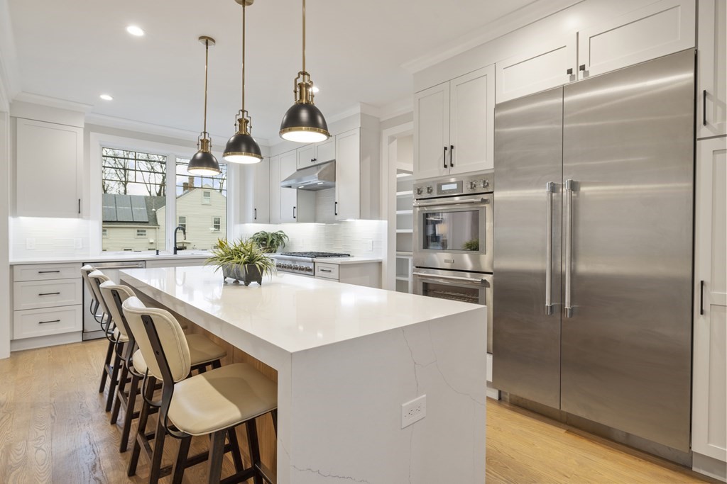 547 Webster Street Needham, MA 02494 - Photo 8 of 39 a kitchen with kitchen island a refrigerator a table and chairs in it