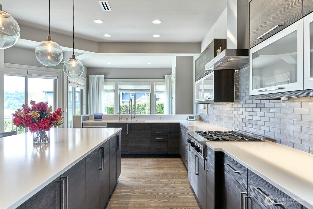3319 Burnett Avenue North Renton, WA 98056 - Photo 20 of 40 a kitchen with a large island in the center a sink dishwasher and a fireplace with wooden floor