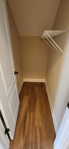 a view of a room with wooden floor and white walls