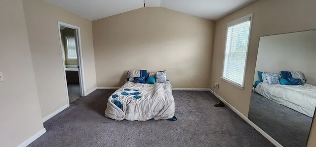 a bedroom with a bed and a window
