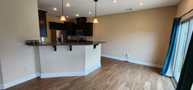 a view of a kitchen with a sink and wooden floor
