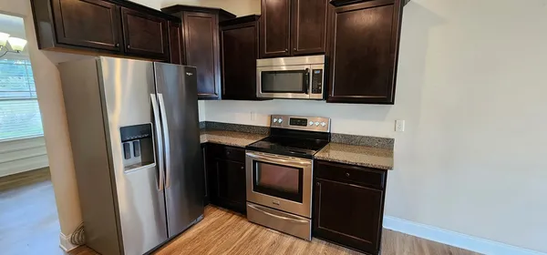 a kitchen with stainless steel appliances granite countertop a refrigerator stove and microwave