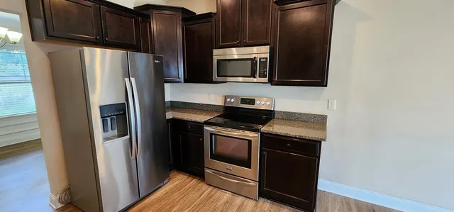 a kitchen with stainless steel appliances granite countertop a refrigerator stove and microwave