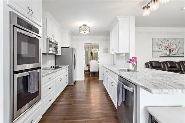 a large kitchen with stainless steel appliances granite countertop a stove refrigerator and a sink