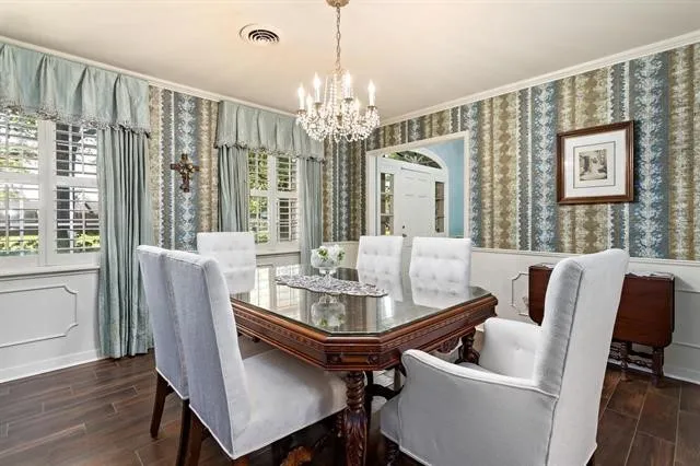 a dining room with furniture a chandelier and wooden floor