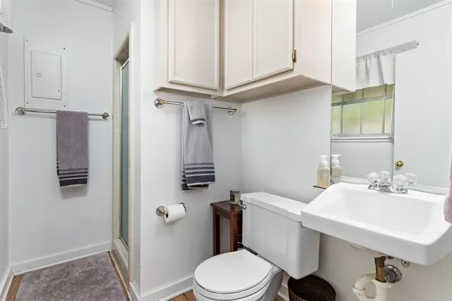 a bathroom with a sink a toilet and shower