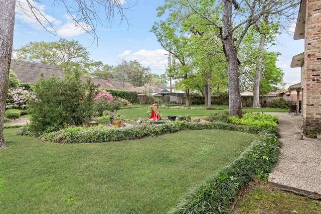 1535 Infinity Lane Beaumont, TX 77706 - Photo 33 of 35 a view of a garden with a fountain and large trees