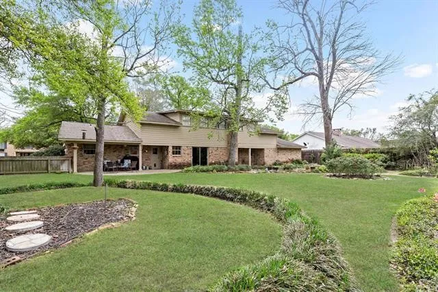 a front view of a house with a garden and trees
