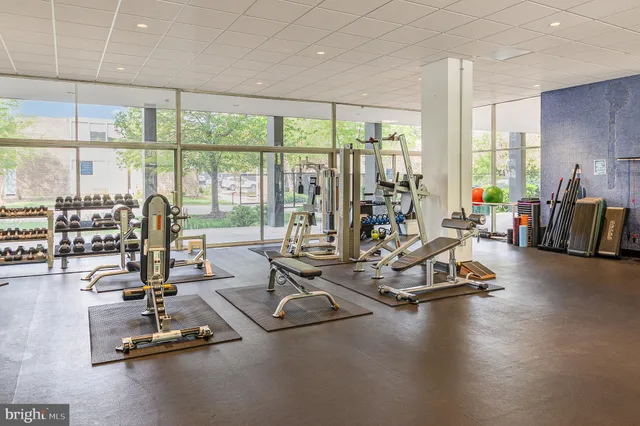 a room with gym equipment and large windows