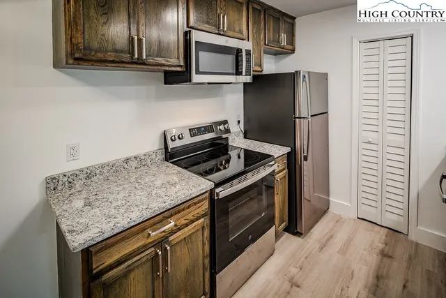 a kitchen with stainless steel appliances granite countertop a stove microwave and refrigerator