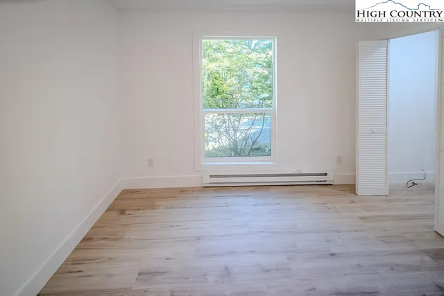 a view of a room with wooden floor and window
