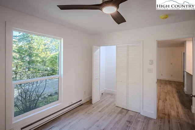 a view of a room with wooden floor fan and window
