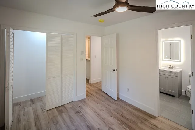 a view of an empty room with closet and a window