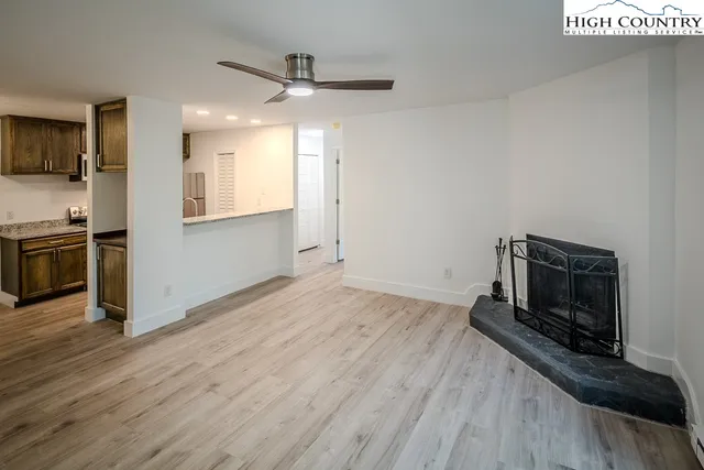 a view of a kitchen with wooden floor electronic appliances and cabinets