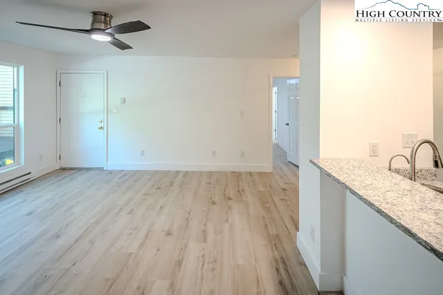 a view of a kitchen with wooden floor and a sink