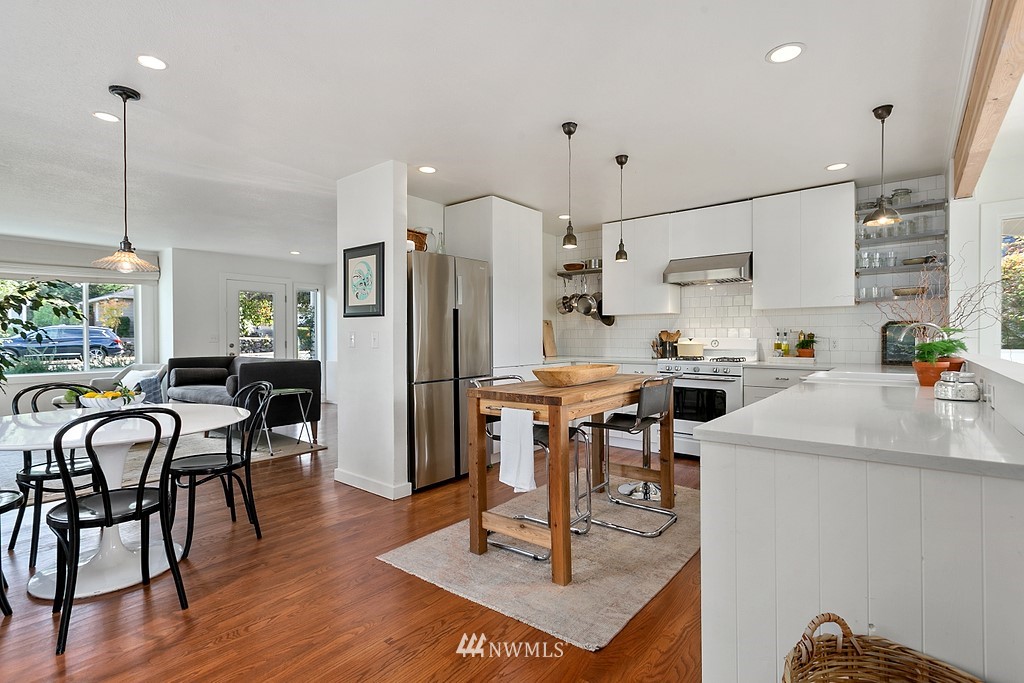 1102 North 30th Street Renton, WA 98056 - Photo 5 of 38 a kitchen with kitchen island a dining table chairs refrigerator and sink