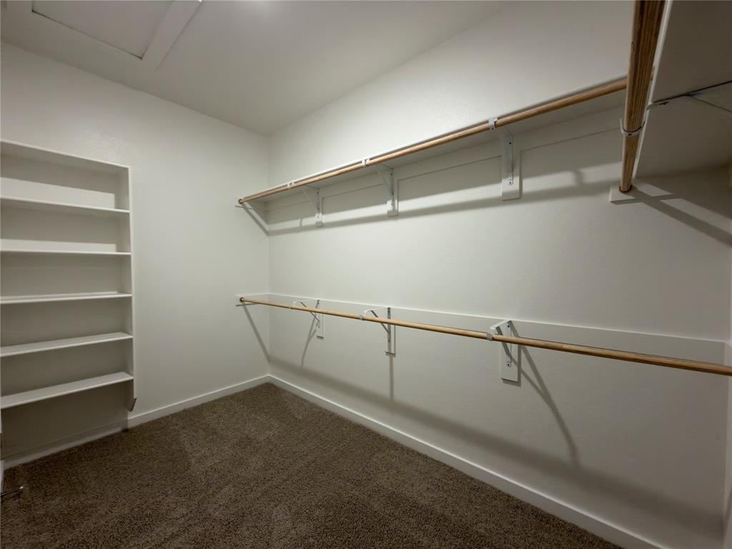 120 Millwood Road Lavon, TX 75166 - Photo 15 of 34 Spacious closet featuring built-in shelving, two levels of hanging rods, and neutral-toned carpeting