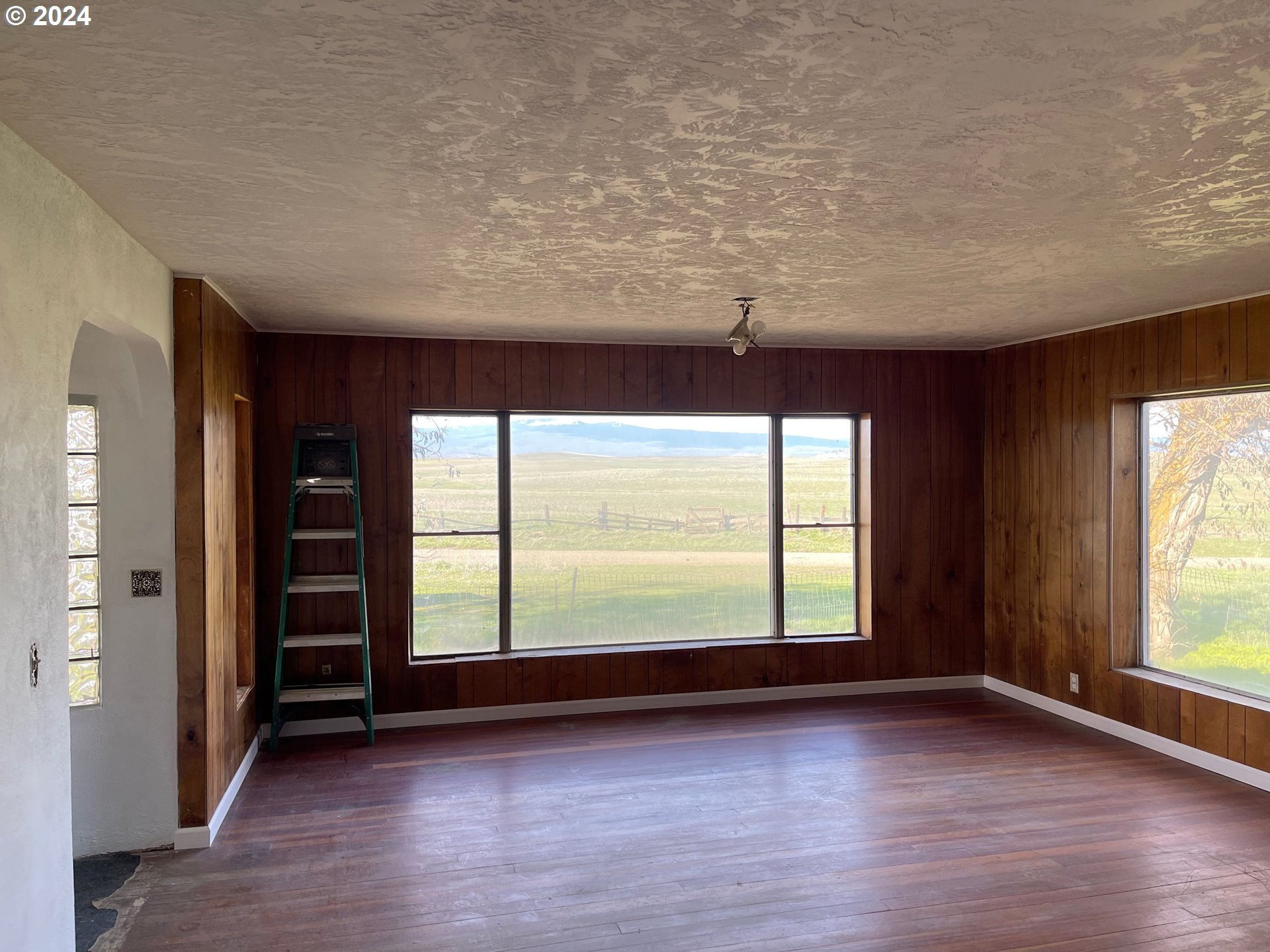 242 Van Hoy Road Goldendale, WA 98620 - Photo 16 of 44 an empty room with wooden floor and windows